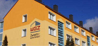 Orangefarbene Hausfassade mit Logo und Schriftzug der WGZ Zwönitz – meine Heimat