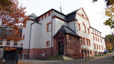 Historisches Gebäude mit roter Sandsteinfassade, Schieferdach und repräsentativem Eingangsportal mit Freitreppe