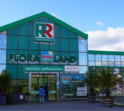 Eingangsbereich des Gartencenters Floraland von Gebrüder Roth mit grüner Glasfassade und Willkommensschrift